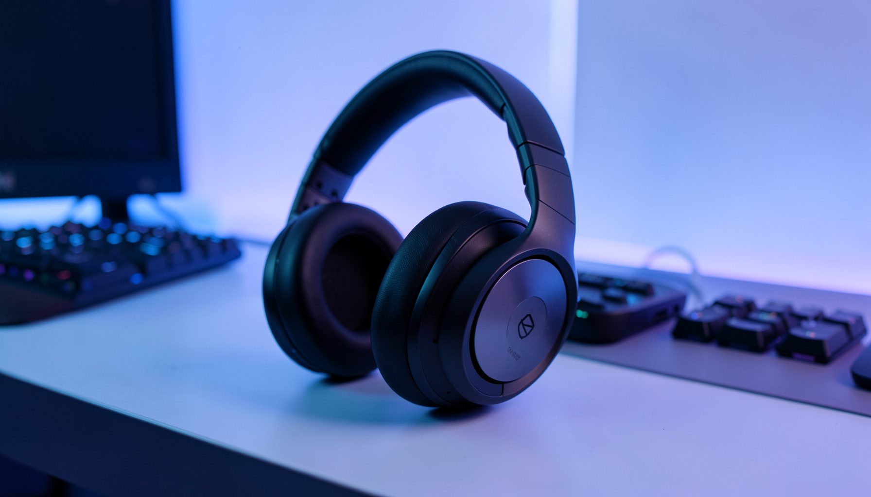 Premium gaming headset with large ear cups on a minimalist desk, soft blue and purple ambient lighting